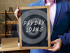 Business concept about PAYDAY LOANS with inscription on the blackboard