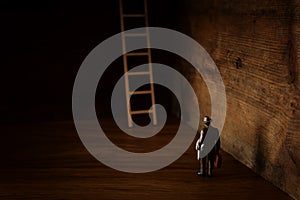 Business concept picture of challenge. A man stands infront of a a ladder. Problem solving and decision making