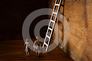Business concept picture of challenge. A man and woman standing infront of a a ladder. Problem solving and decision making