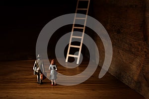 Business concept picture of challenge. A man and woman standing infront of a a ladder. Problem solving and decision making