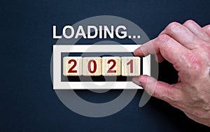 Business concept of planning 2021. Loading new year 2021 with hand putting wood cube in progress bar. Business concept. Beautiful