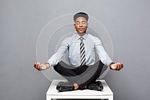 Business Concept - portrait of african american businessman doing meditation and yoga in before working.