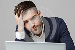 Business Concept - Portrait handsome serious business man in suit looking at laptop. White Background.