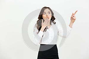 Business Concept: Portrait of surprised young businesswoman pointing finger away to copy space. Isolated on a white