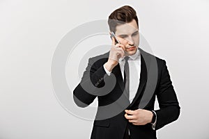 Business Concept: Portrait of young handsome businessman talking on mobile phone with serious and stress expression