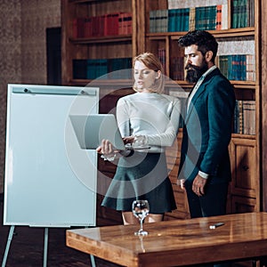 Business concept. Sensual woman and handsome man develop business plan. Couple with laptop search for business ideas in