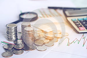 Business concept, stack of coin with calculator,magnifying glass ,financial graph