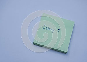 Business concept sticky note with hand writing of salary increase and raise message