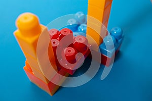 Business concept of success, teamwork and building a business. Color toy blocks on blue background