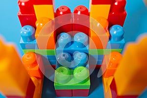 Business concept of success, teamwork and building a business. Color toy blocks on blue background