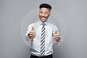 Business Concept - Successful African American Businessman showing thump up in front of him.