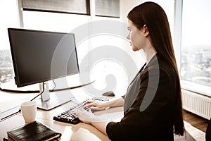 Business concept. Successful young businesswoman at work. Manager sitting at the office table and working on computer