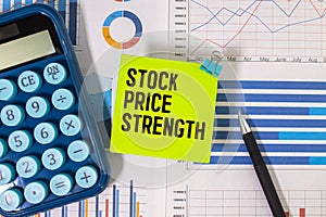 Business concept. On the table are coins, a pen, a graph and a sign with the inscription - STOCK PRICE STRENGTH