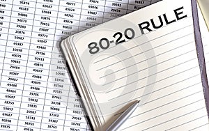 Business concept, on the table a notepad with the text of the 80- 20 rule , profit, loss and graph