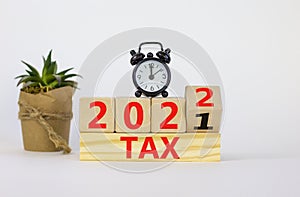 Business concept of tax planning 2022. Turned a wooden cube and changed words `Tax 2021` to `Tax 2022`. Beautiful white backgr