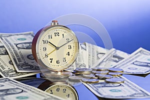 Business concept. Time is money. Vintage clock near american dollar cash and coins with nice blue gradient background