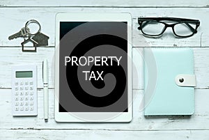 Business concept, Top view of home key,calculator,pen,glasses,notebook and tablet pc written with Property Tax.