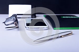 Business concept. Top view of kraft spiral notebook, glasses, smartphone and black pen