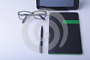 Business concept. Top view of kraft spiral notebook, glasses, smartphone and black pen isolated on background for mockup