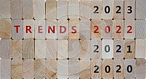 Business concept of 2022 trends. Wooden cubes with words `TRENDS 2022` and numbers 2020, 2021, 2023. Beautiful wooden background photo