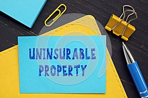 Business concept about UNINSURABLE PROPERTY with sign on the financial document