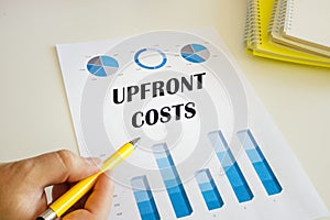 Business concept about UPFRONT COSTS with sign on the financial document photo