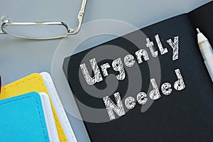 Business concept about Urgently Needed with sign on the page