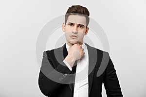 Business Concept: Young handsome businessman in suit thinking with hand on chin, business strategies concept