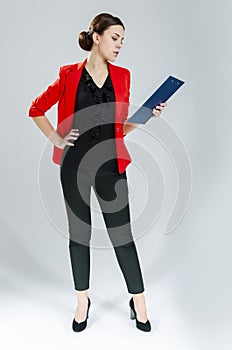 Business Concepts. Full Length Portrait of Female Enterpreneur Posing in Red Jacket. Holding Notepad Against White
