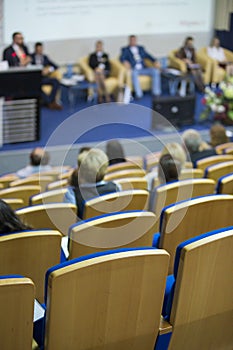 Business Concepts. Group of Hosts Sitting on Stage At Table During a Meeting