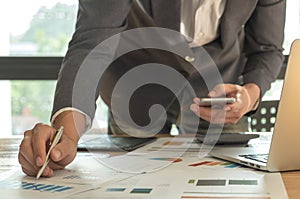 Business concepts,Man hand holding pen pointing at graph on desk