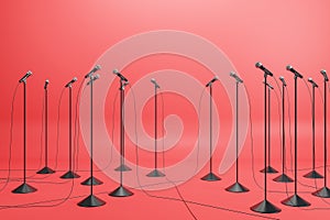 Business conference concept with floor stand microphones on red background