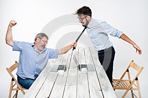 Business conflict. The two men expressing negativity while one man grabbing the necktie of her opponent