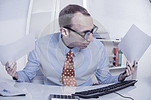 Business - confused and overworked businessman waving papers in