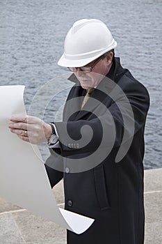 Business construction man ingineer architect with blueprint on the work site overlooking project