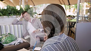 Business conversation. young woman talking with man in cafe and gestures