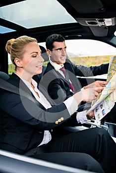 Business couple in car travelling