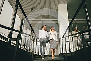 Business couple coming down the stairs