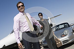 Business Couple Holding Hands At Airfield photo