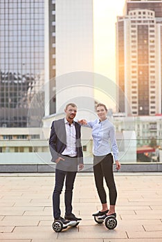 Business couple on hoverboards.