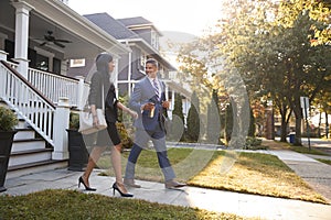 Business Couple Leaving Suburban House For Commute To Work photo