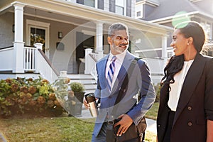 Business Couple Leaving Suburban House For Commute To Work