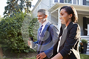 Business Couple Leaving Suburban House For Commute To Work