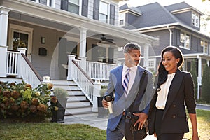 Business Couple Leaving Suburban House For Commute To Work photo