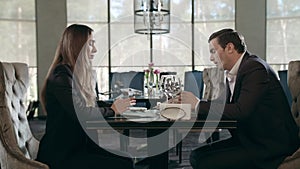 Business couple meeting in restaurant. Adult man and woman talking at cafe table