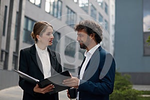 Business Couple Outdoors Examining Documents. People Discussing Project