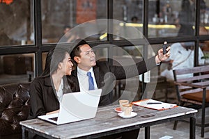 business couple taking a photo of herself using smartphone