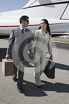 Business Couple Walking Together At Airfield photo