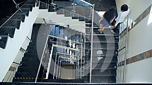 Business couple walking up stairs together. The view from the top