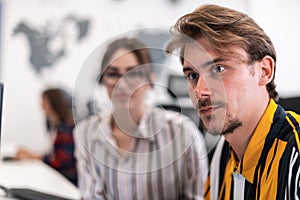 Business couple working together on project using tablet and desktop computer at modern open plan startup office